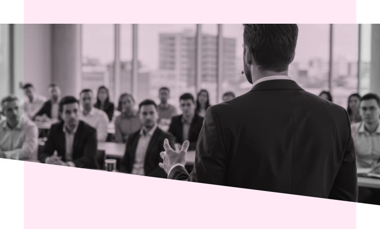 A man talking to a mix of men and women in business clothes