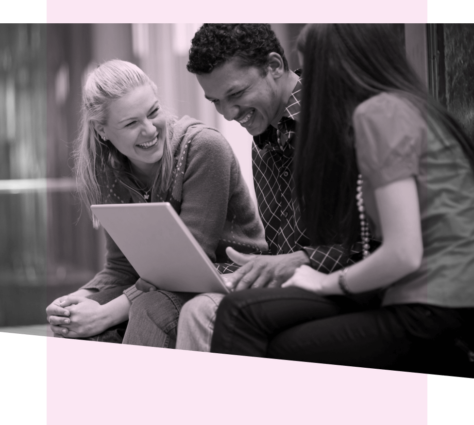 Three people smiling working on a laptop